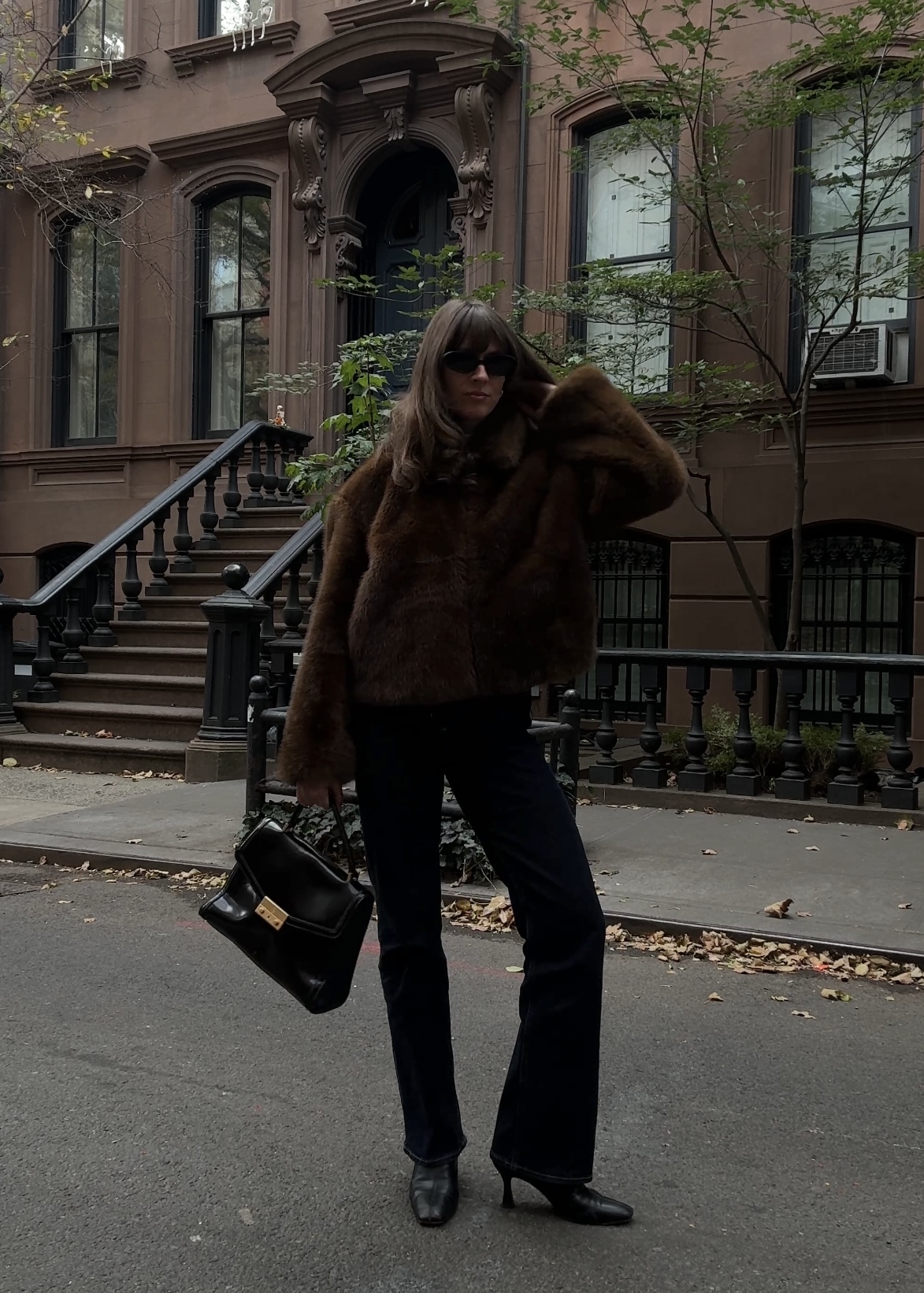 Kathryn Zahorak in new york wearing faux fur coat, sunglasses, black pants, and boots