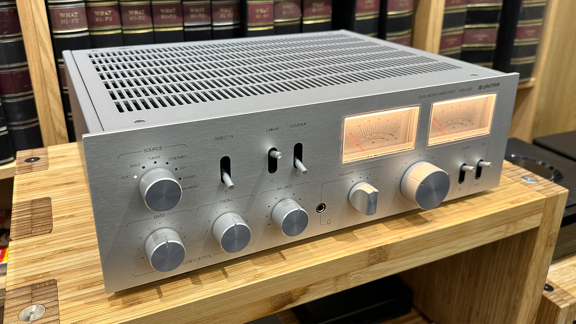 Unitra WSH-805 integrated amplifier on wooden hi-fi rack in front of bookcase