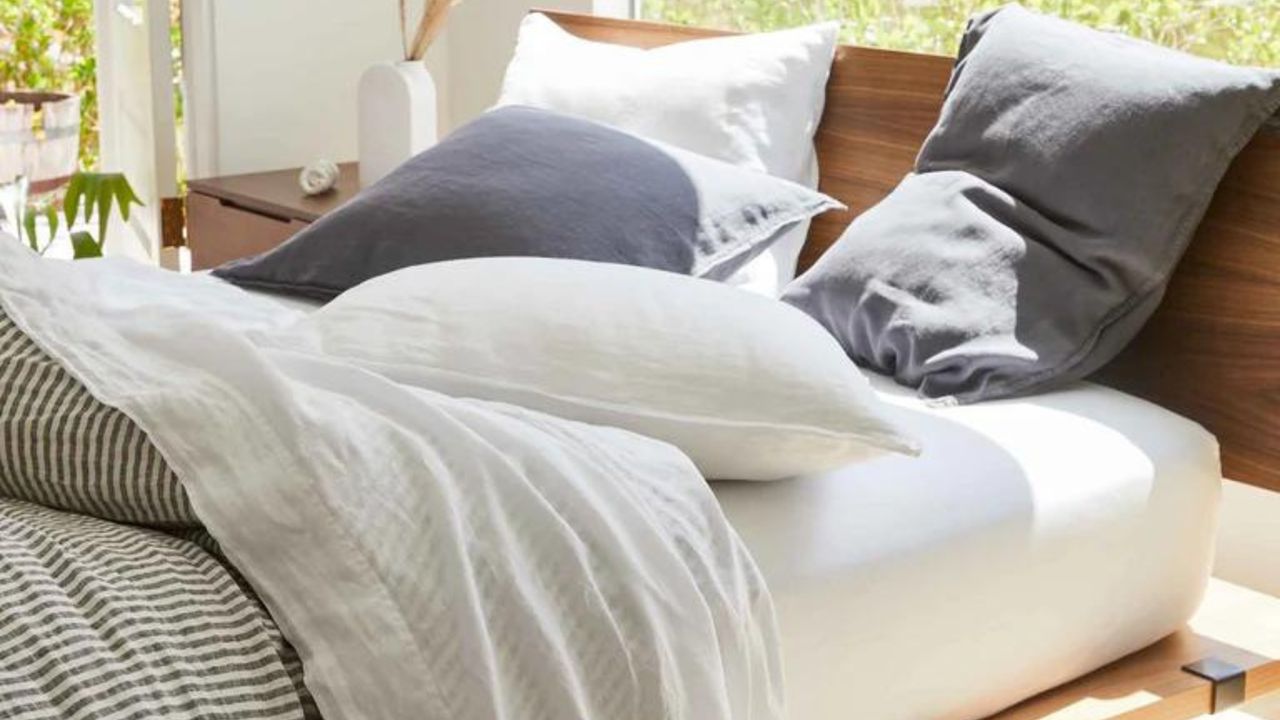 Bed with white duvet and navy linen pillows