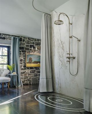 A shower room in the middle of the bathroom with a curtain enclosure