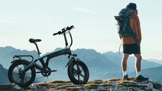 Man standing on mountain with Fuell Folld-1 e-bike