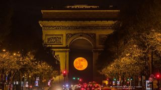 The full moon beneath Paris' Arc de Triomphe on April 17, 2022.