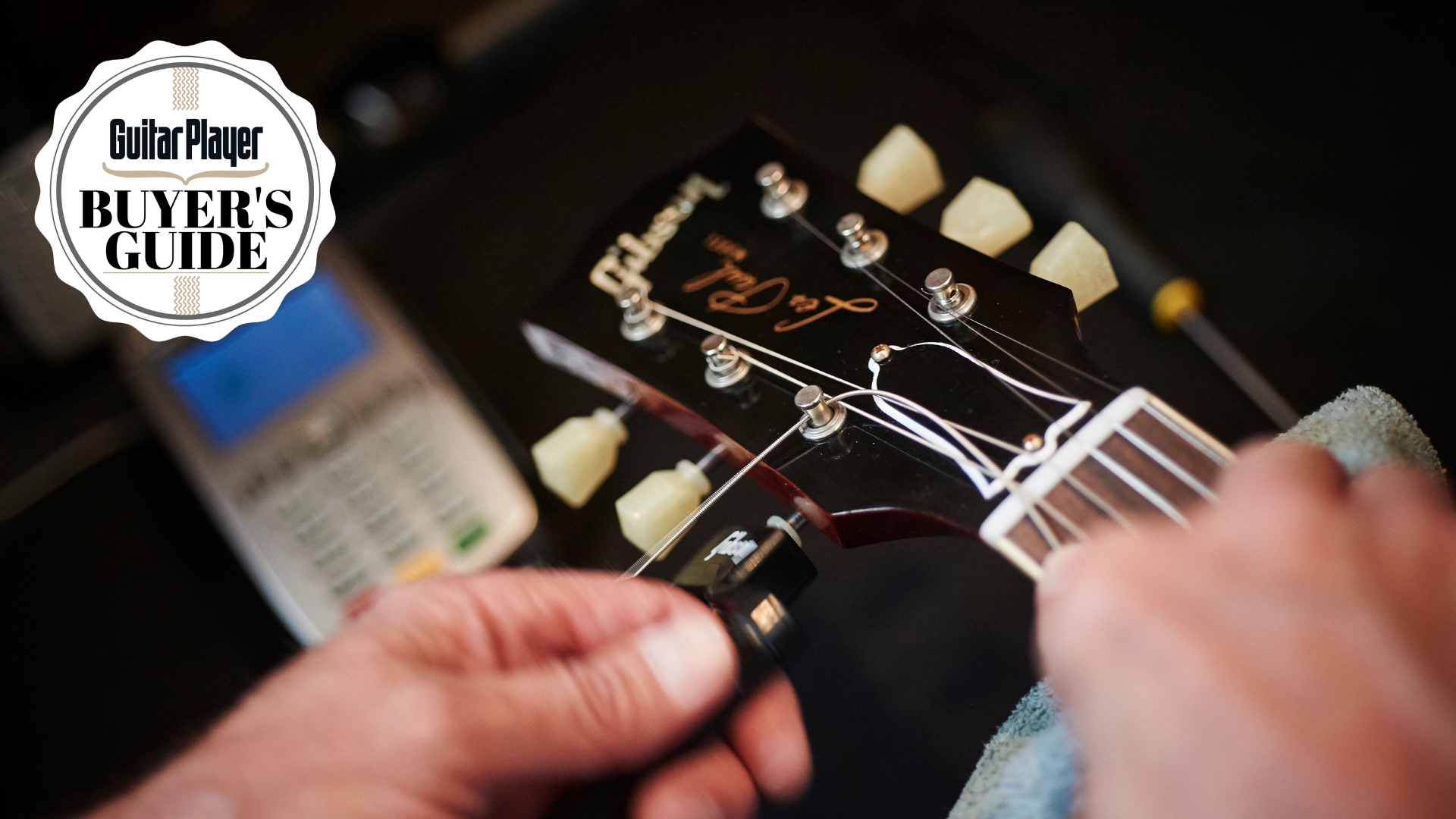 A man changes electric guitar strings on a Gibson Les Paul guitar