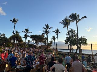 People stand up to practice hula moves at the Old Lahaina Luau in Maui