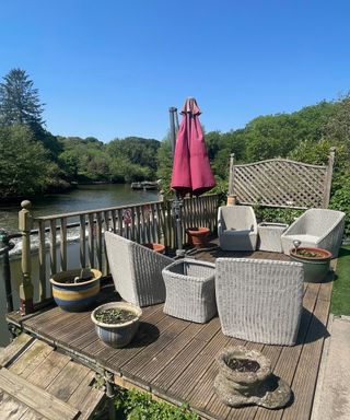 patio next to a river with patio furniture and an umbrella