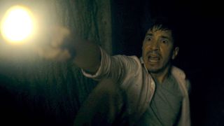 Justin Long scared with flashlight in Barbarian