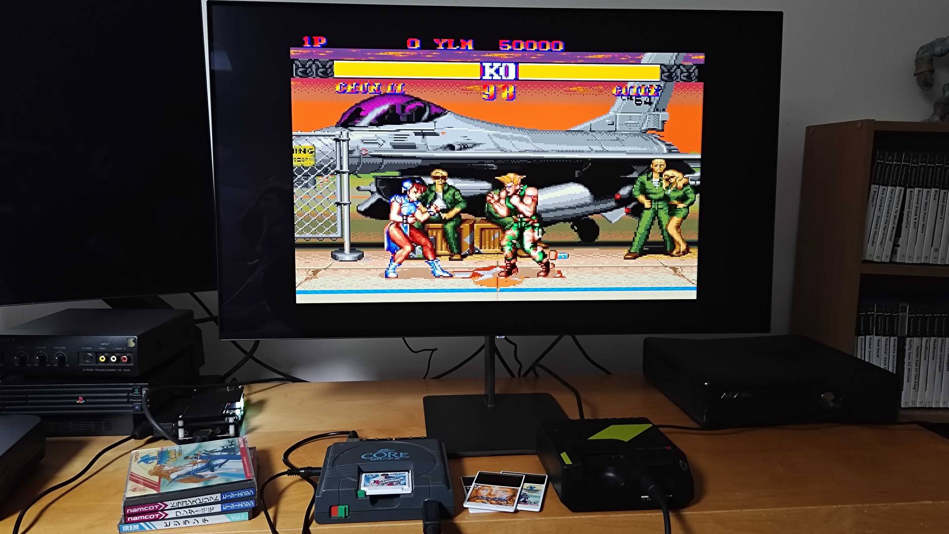 PC Engine next to Hyperkin Retron GX running Street Fighter 2 beneath monitor.