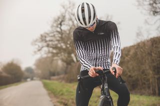 Image shows rider looking at their cycle computer on a ride outside.