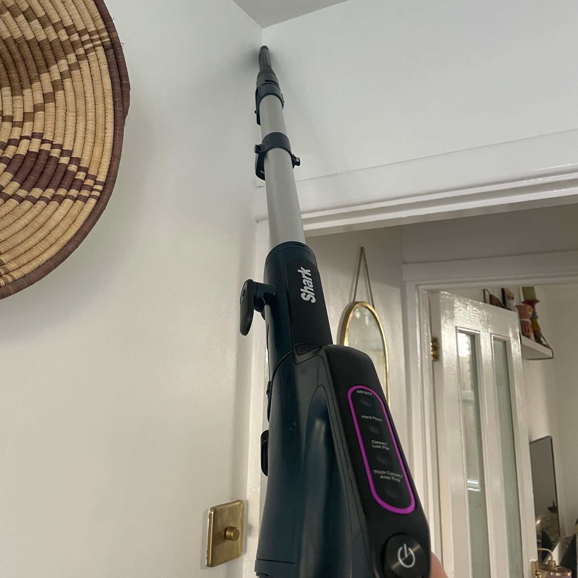 Using the extension pole to clean corner of a white painted room with the Shark PowerDetect Powered Lift-Away Upright Pet Vacuum Cleaner AZ3900UKT 