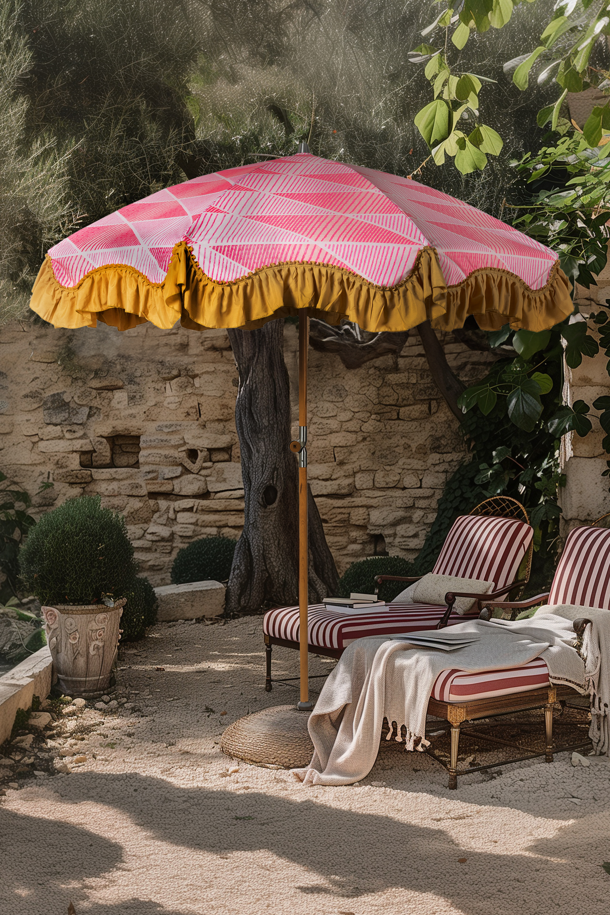 Pink parasol with mustard lining and striped red sunloungers in garden