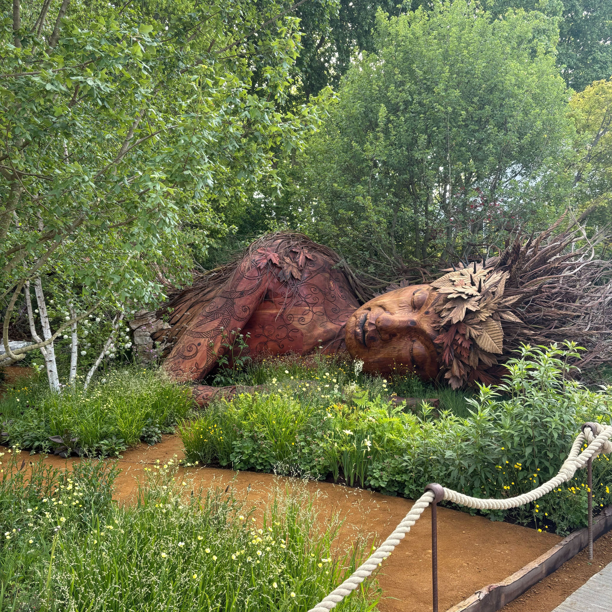A wooden Gaia scultpure at Chelsea Flower Show 2026.