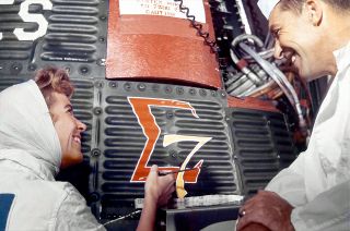 Chrysler Aerospace artist Cece Bibby applies the Sigma 7 logo on the side of astronaut Wally Schirra's Mercury-Atlas 8 spacecraft in 1962.