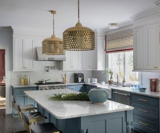 Blue wooden kitchen island, white tiles, gold lampshade