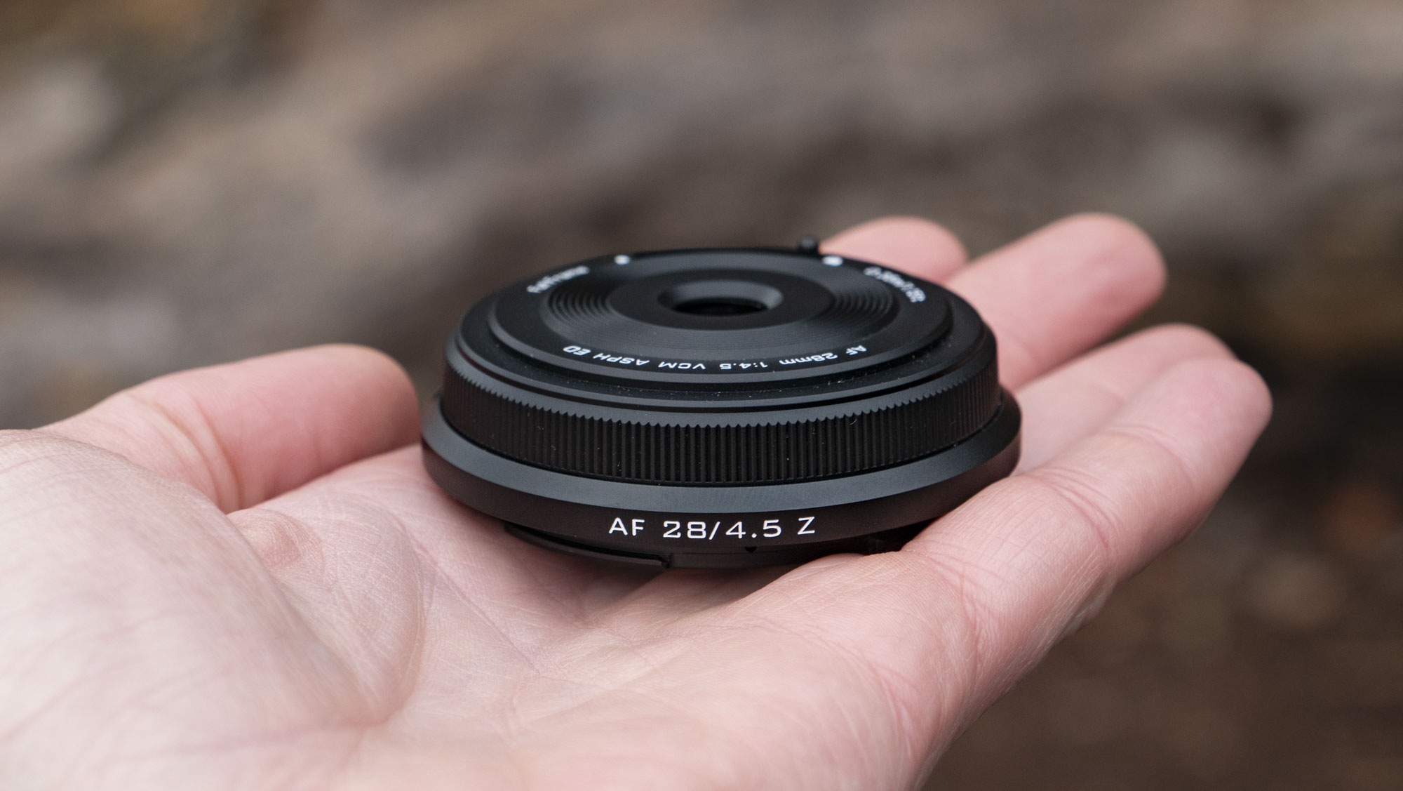 Viltrox AF 28mm f/4.5 body cap lens in photographer's hand