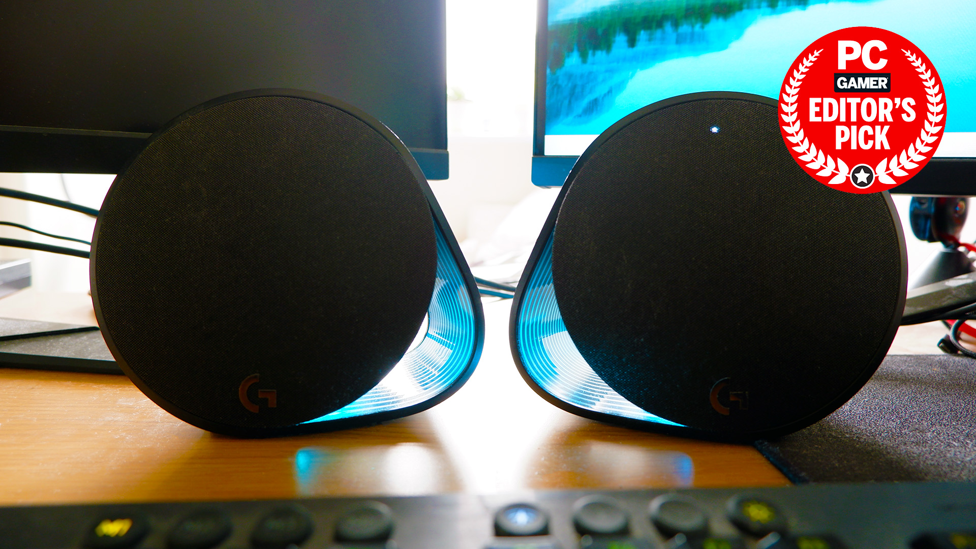 Logitech speakers on a desk with blue lighting enabled