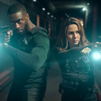 aldis hodge as alex cross and alona tal as kayla craig pointing guns and flash lights walking down a dark lit hallway in a still from cross season 2