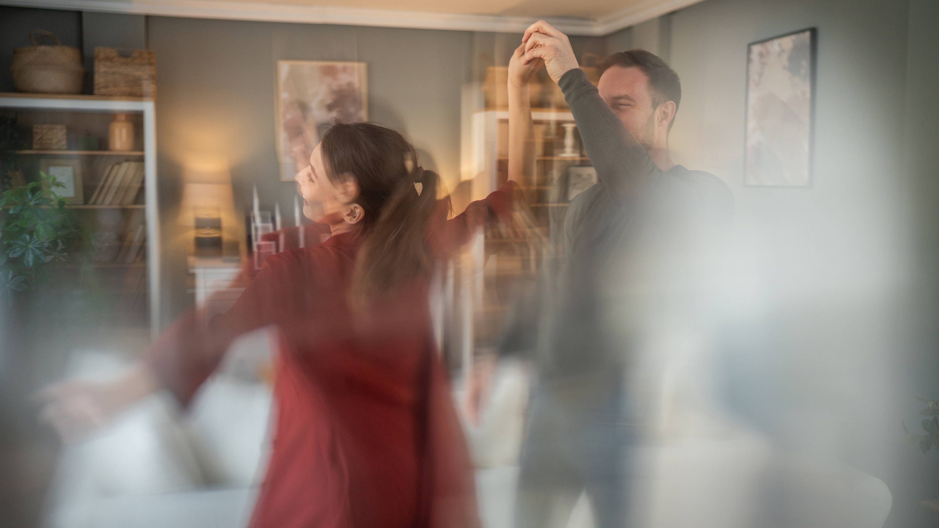 A blurred image of a couple dancing in their living room.