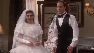 A shot of Mayim Bialik in a poofy white outdated wedding dress and of Jim Parsons in a bowtie, starched shirt and black vest in The Big Bang Theory wedding scene.