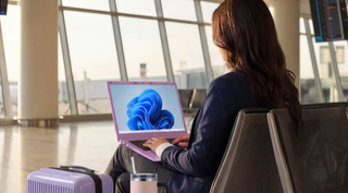 Staples campaign imagery of a lady holding a laptop in the airport