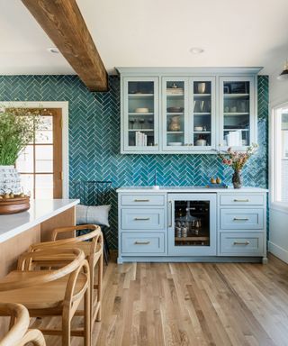 kitchen with light blue cabinets, teal wall tiles, wooden flooring and white ceiling with exposed wooden ceiling beam