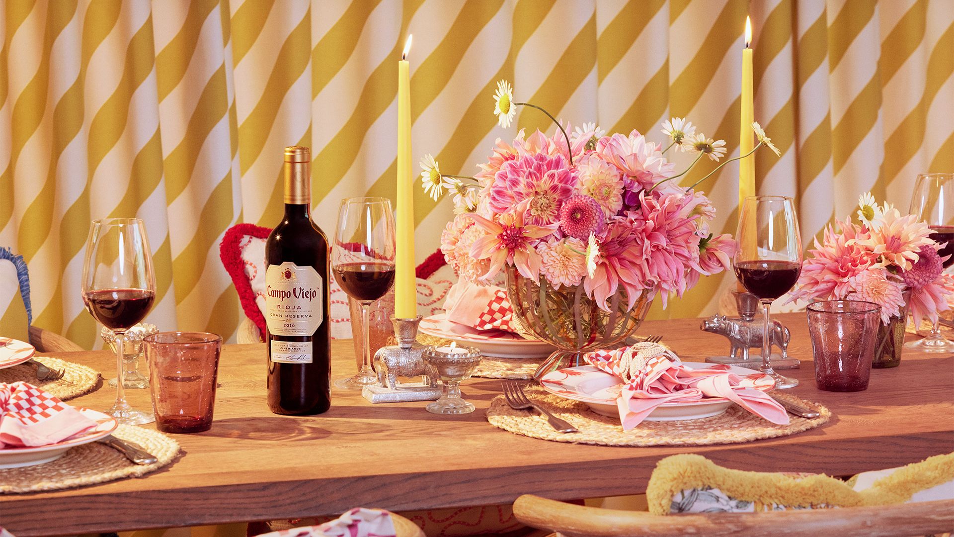 pink and yellow tablescape with bottle of red wine