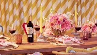 pink and yellow tablescape with bottle of red wine