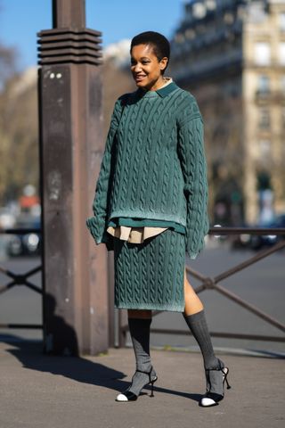Tamu McPherson wearing a green sweater set and heels
