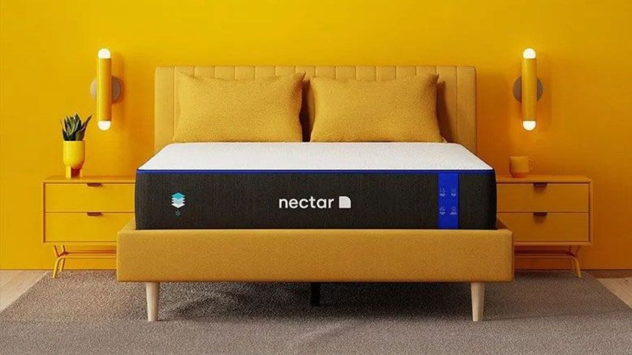 A Nectar mattress on a bed beside two yellow nightstands against a bright yellow wall.