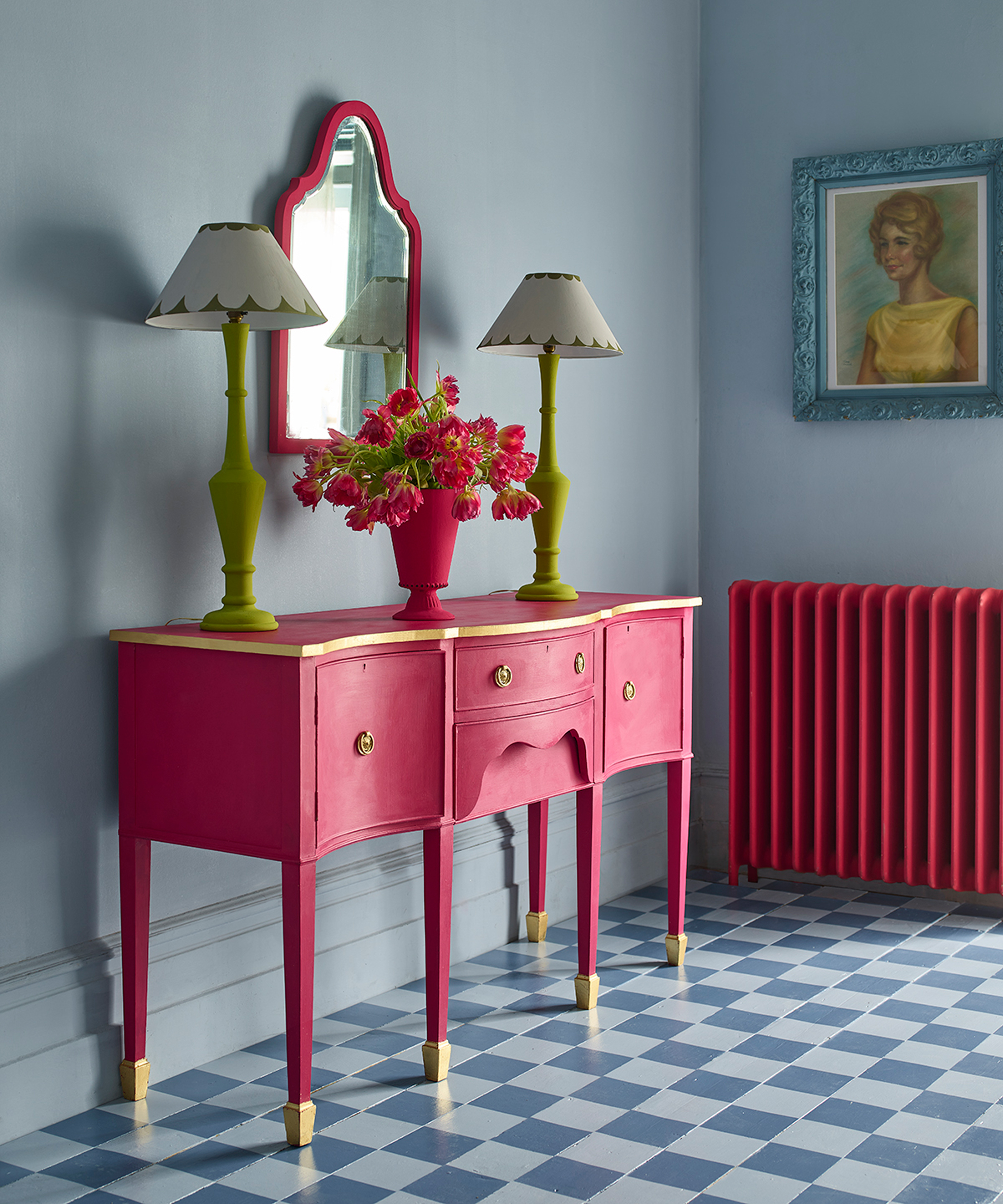 Modern hallway scheme with bright pink painted console and radiator, and blue contrast painted check design on floor.