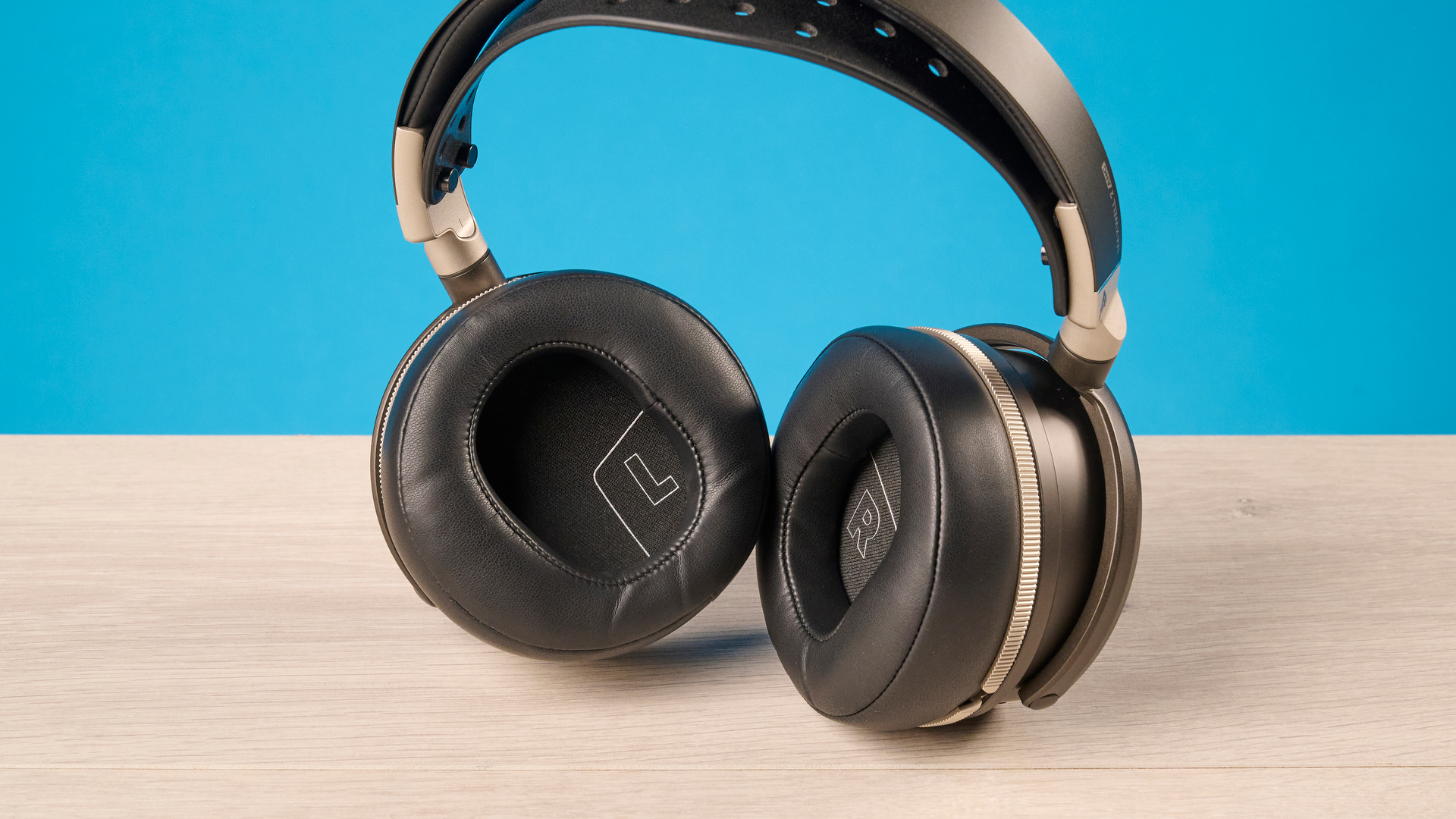 The Audeze Maxwell 2 ANC on a wooden desk with a blue background