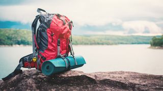 A backpack loaded up for an overnight adventure sits on a rock