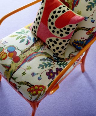Close-up of orange chair upholstered with Vegetable Tree printed fabric by Josef Frank, for India Mahdavi Svenskt Tenn exhibition