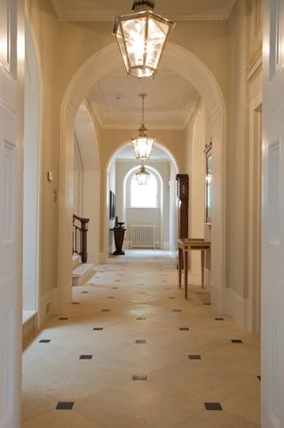 elegant arched hall in a period home with stone floor tiles