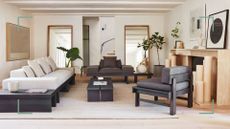 Japandi styled living room with low furniture with black wooden frames comfortable cream cushions low coffee table and numerous plants