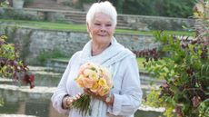 Dame Judi Dench holds a bouquet of flowers at the RHS Wisley Flower Show