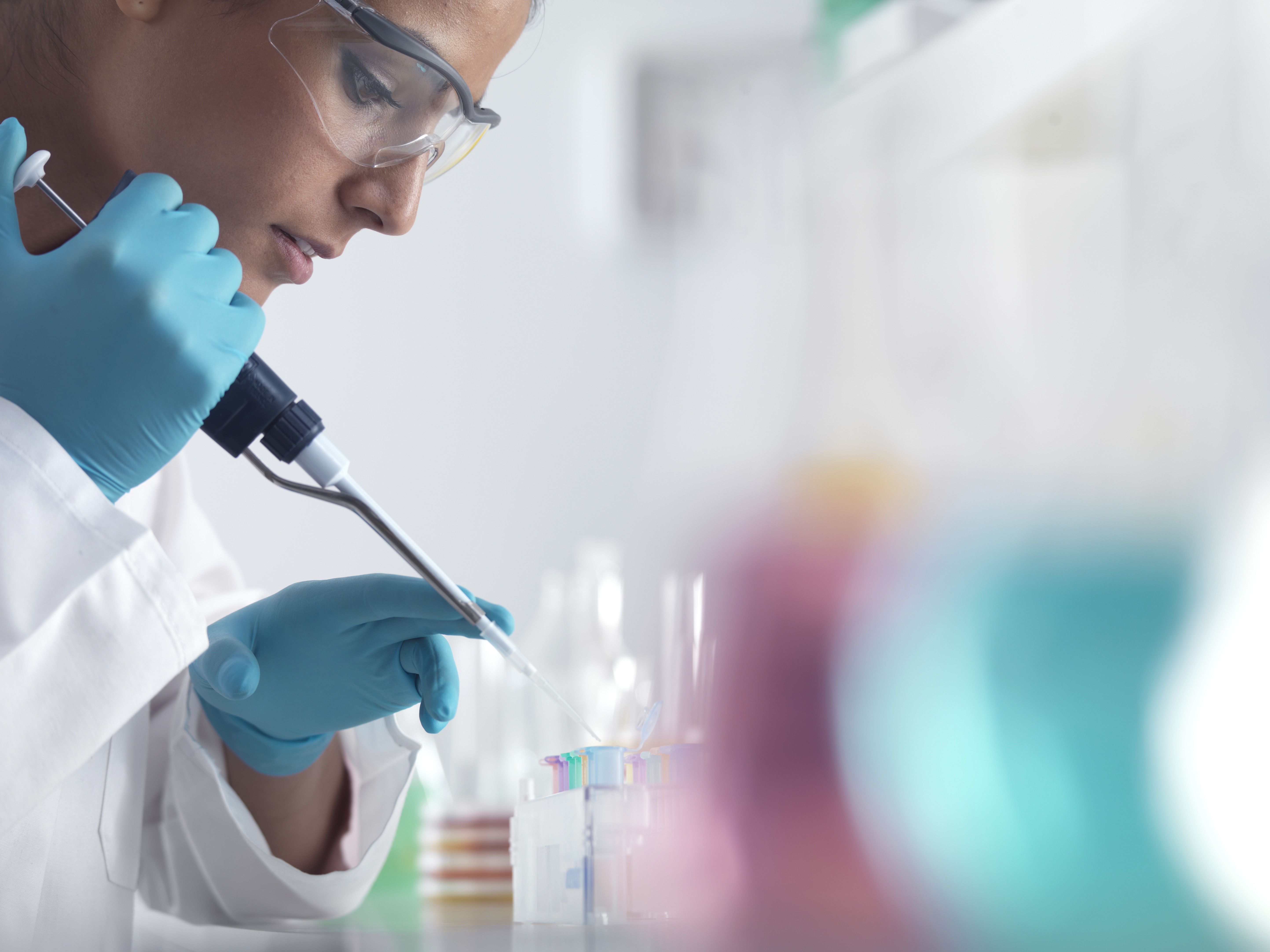 Scientist pipetting samples into micro centrifuge tubes ready for automated analysis