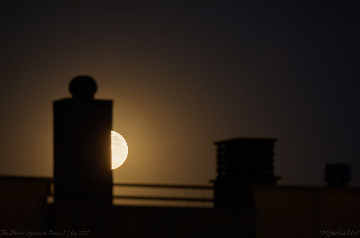 The Full Flower Moon plays &ldquo;peekaboo&rdquo; among rooftop structures in Rome, Italy in this view by astrophysicist Gianluca Masi of the Virtual Telescope Project, on May 7, 2020.