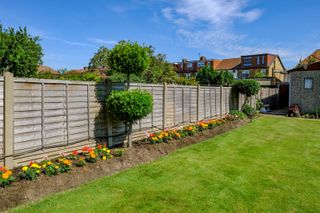 A neatly cut lawn edge in a garden with a well weeded flower bed