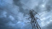 An electric pylon stands in a field