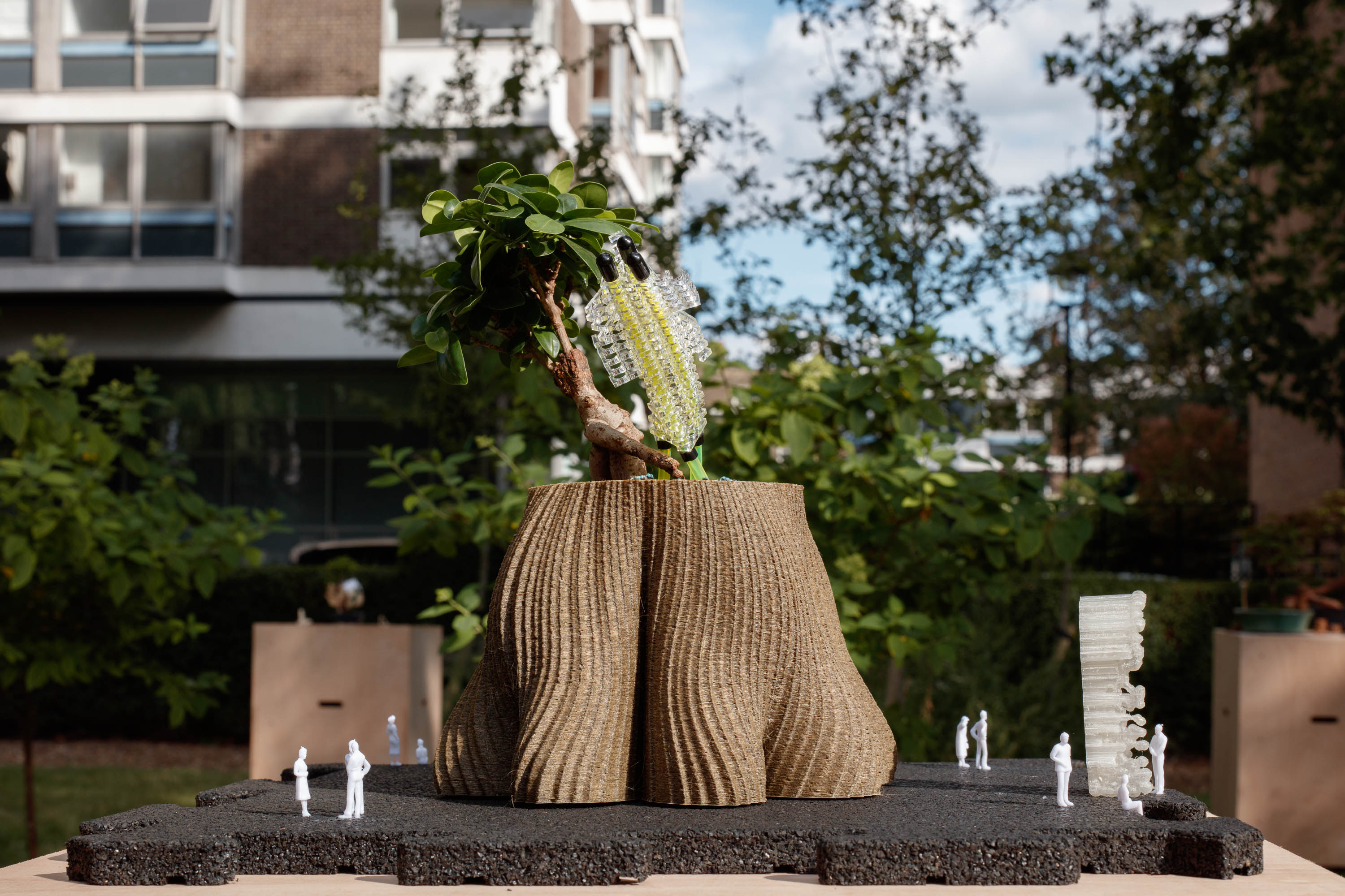 view of miniature houses in a park as part of an open air Bonsai treehouse exhibition in London