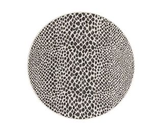 A round outdoor rug with a muted animal print pattern