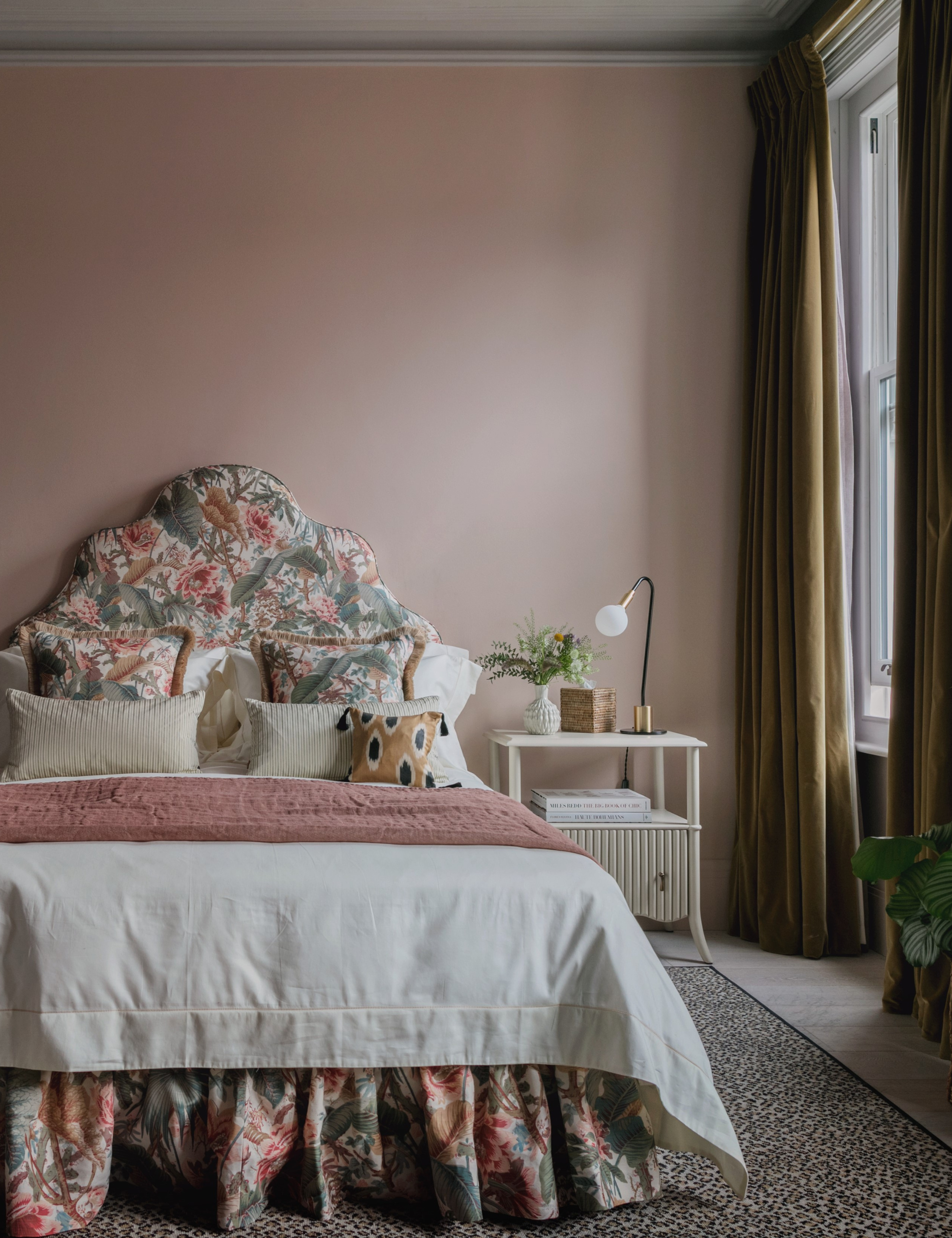Patterned bedscape, featuring floral, ikat, and striped bed linens, pictured in a blush pink bedroom