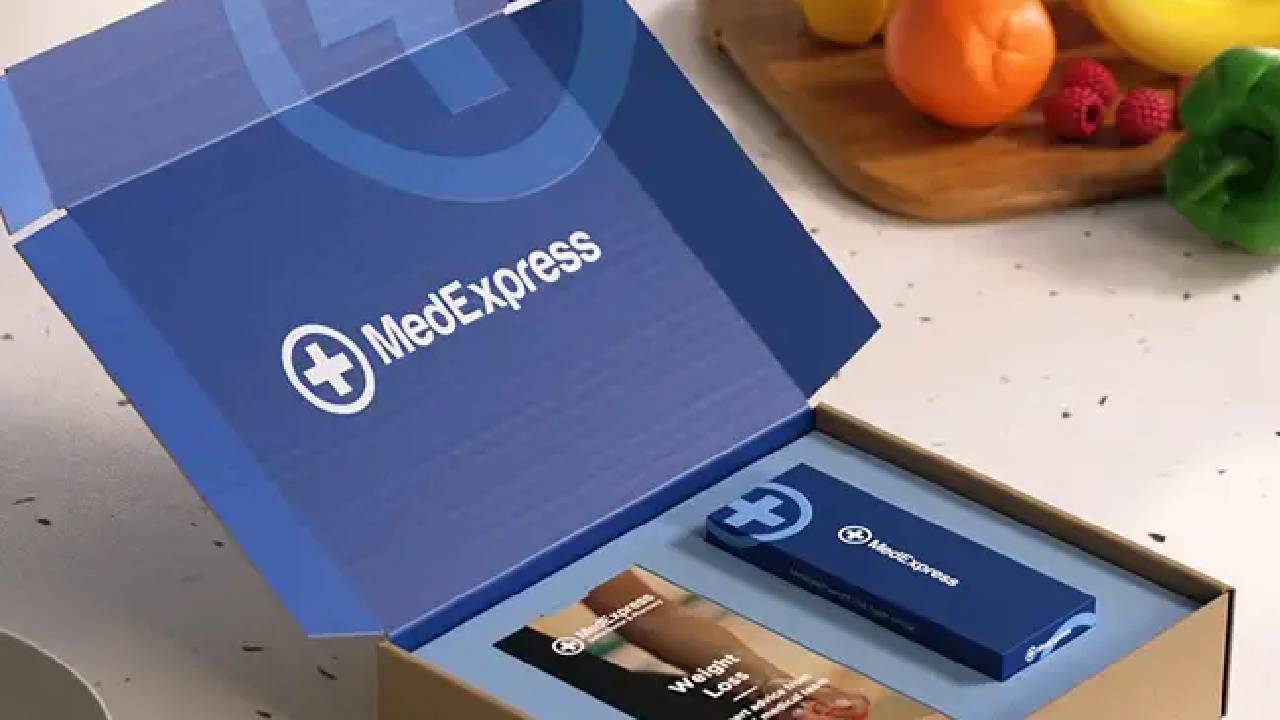 A box from MedExpress on a surface next to fruit.