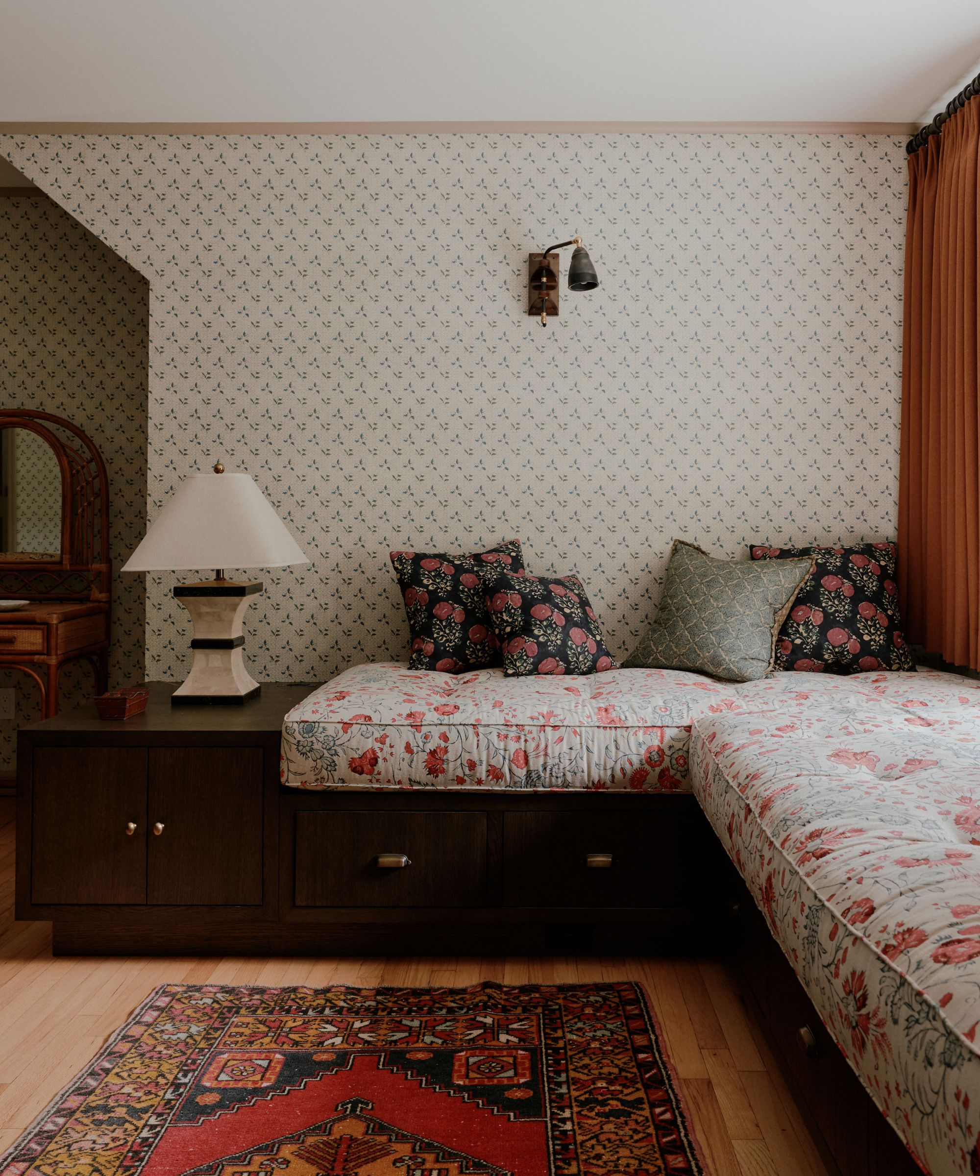 bedroom chintz window seat with pillows and floral wallpaper