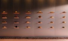 Each pastry is displayed on its own unique shelf ledge. There are six columns of illuminated shelves with 24 shelves in total.