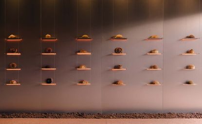 Each pastry is displayed on its own unique shelf ledge. There are six columns of illuminated shelves with 24 shelves in total.