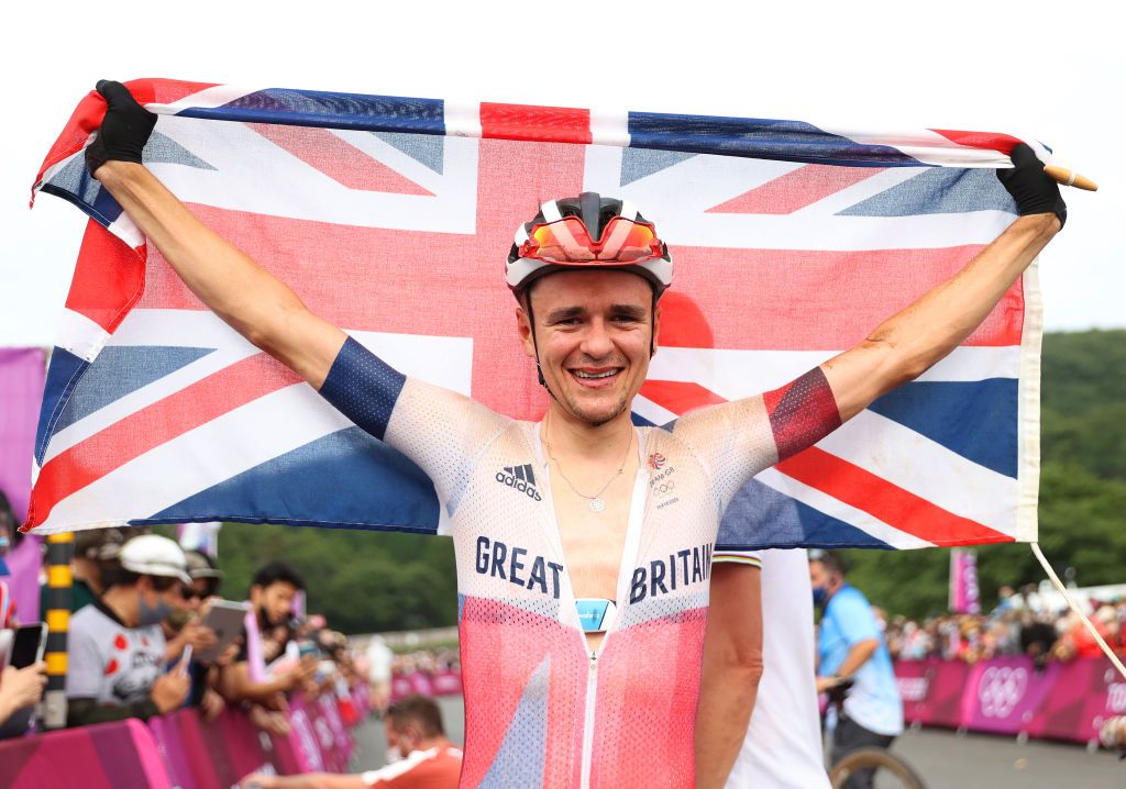 IZU JAPAN JULY 26 Thomas Pidcock of Team Great Britain celebrates winning the gold medal while holding the flag of his country during the Mens Crosscountry race on day three of the Tokyo 2020 Olympic Games at Izu Mountain Bike Course on July 26 2021 in Izu Shizuoka Japan Photo by Michael SteeleGetty Images