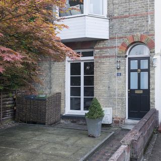 house exterior with red bricked wall and white window