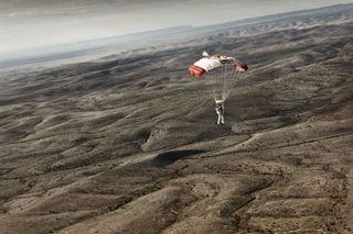 Pilot Felix Baumgartner of Austria descends to the desert after successfully completing the second manned test flight for Red Bull Stratos in Roswell, New Mexico