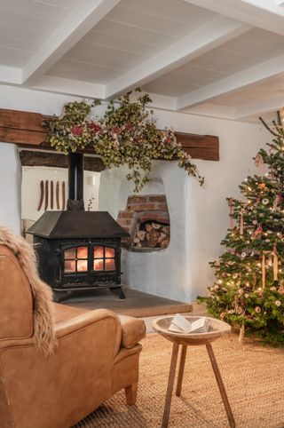 Christmas living room cozy with natural mantelpiece garland and tree by Unique Homestays